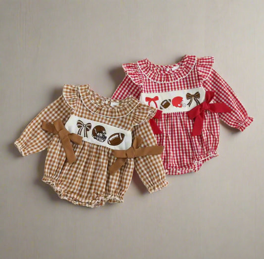 Two baby rompers, one brown checkered and one red checkered with decorative elements, on a beige background.